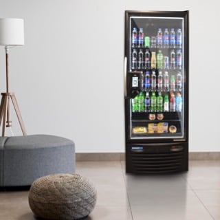 Der Hightech-Kühlschrank PicoCooler von 365 Retail Markets steht vor einer weißen Wand in einem modernen Pausenraum mit Sitzgelegenheiten.